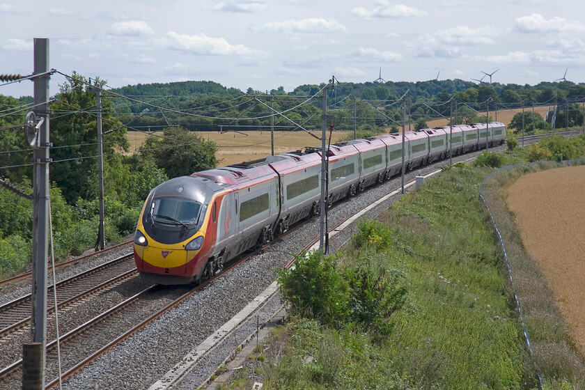 390131, VT 10.45 London Euston-Glasgow Central (1S45), Blisworth 
 390131 'City of Liverpool' sweeps around the sharp curve near Blisworth as it commences the winding section of its journey as far as Hillmorton Junction just south of Rugby. It is working the 1S45 10.45 Euston to Glasgow Central Virgin service. Notice the top of the M1 wind farm turbines just above the trees on the skyline 
 Keywords: 390131 10.45 London Euston-Glasgow Central 1S45 Blisworth Virgin West Coast Pendolino City of Liverpool