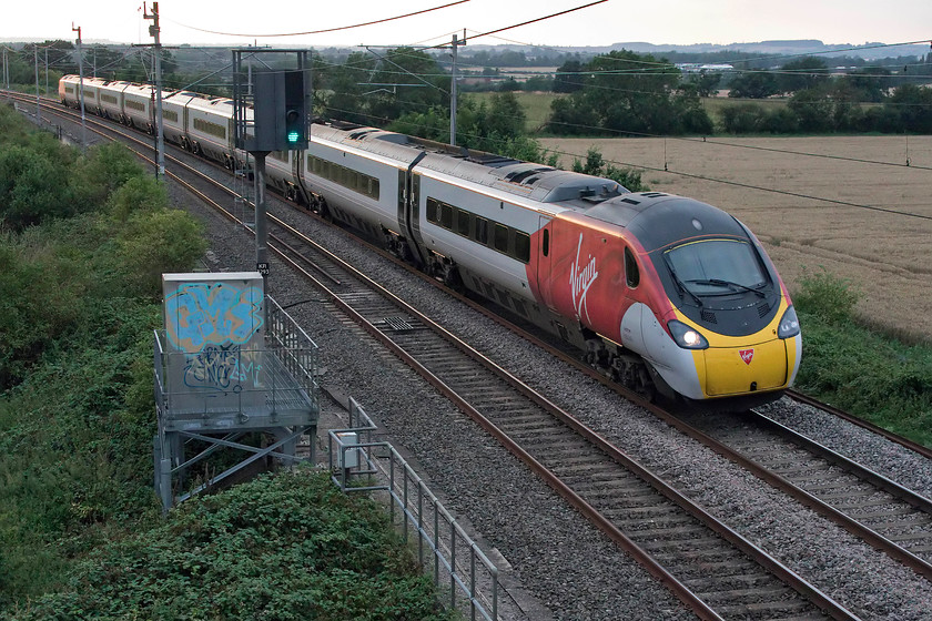 390047, VT 18.03 Crewe-London Euston (9M47, 6E), Milton Crossing 
 The sky to the north at Milton Crossing, between Roade and Blisworth, is looking a little brighter as 390047 passes working the 18.03 Crewe to London Euston. This particular Pendolino was the one selected and used for the September 2007 Glasgow to Euston record attempt. 
 Keywords: 390047 18.03 Crewe-London Euston 9M47 Milton Crossing