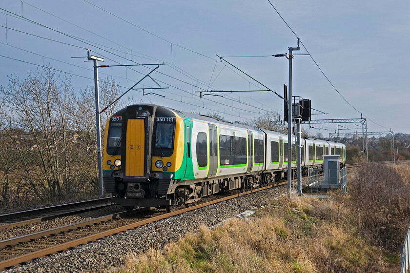 350101, LM 11.13 London Euston-Birmingham New Street, Wilson's Crossing 
 350101 climbs away from Northampton at Wilson's Crossing near Kingsthorpe working the 11.13 Euston to Birmingham service. The London Midland livery contrasts well with the winter sky on this bright day. 
 Keywords: 350101 11.13 London Euston-Birmingham New Street Wilson's Crossing London Midland Desiro