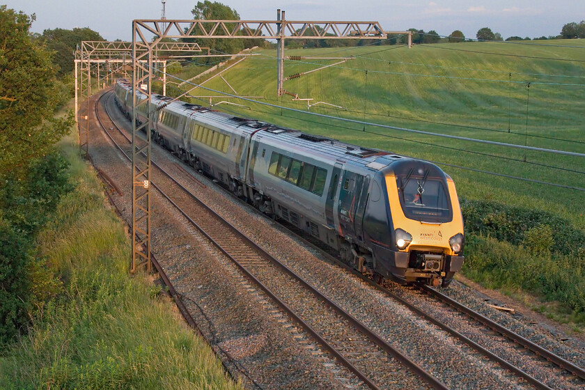 221112 & 221114, VT 18.02 London Euston-Wrexham General (Cancelled from Crewe), (1J32, 134L), Milton crossing 
 Again problems further south on the WCML closer to London have affected services with all northbound trains running late with some cancellations. With the last vestiges of summer sun on the longest day illuminating the scene at Milton crossing between Roade and Blisworth 221112 and 221114 work the very late running 18.02 Euston to Wrexham Avanti service that should have passed this spot about two hours previously. Later on, the train was cancelled at Crewe arriving one hundred and thirty-four minutes late; I hope that the beleaguered passengers for Chester and Wrexham where offered onward transportation. 
 Keywords: 221112 221114 18.02 London Euston-Wrexham General Cancelled from Crewe 1J32 Milton crossing