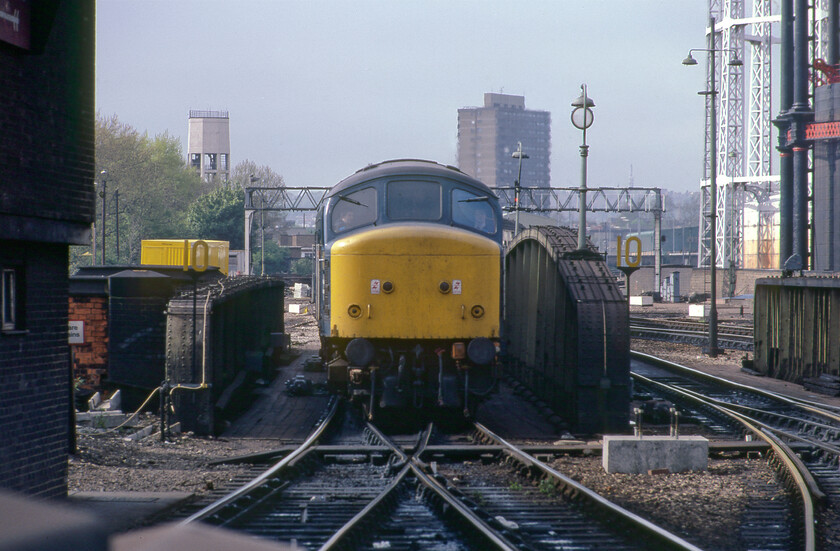 45123, 14.07 Derby-London St. Pancras (1C59), London St. Pancras throat 
 Taken using my 135mm zoom lens on my Pentax ME Super 45123 'The Lancashire Fusilier' enters St. Pancras station crossing over the bridge that spanned Goods Way that itself linked Pancras Road with York Way. With the bulk of St. Pancras' signal box to the left, see.... https://www.ontheupfast.com/p/21936chg/27444294604/st-pancras-signal-box this scene is completely unrecognisable today! The Peak is leading the 1C59 14.07 ex Derby service into platform two. Incidentally, 45123 had a further five years in service ending its days at Vic Berry's infamous scrapyard in Leicester finally being cut up in 1988. 
 Keywords: 45123 14.07 Derby-London St. Pancras 1C59 London St. Pancras throat The Lancashire Fusilier