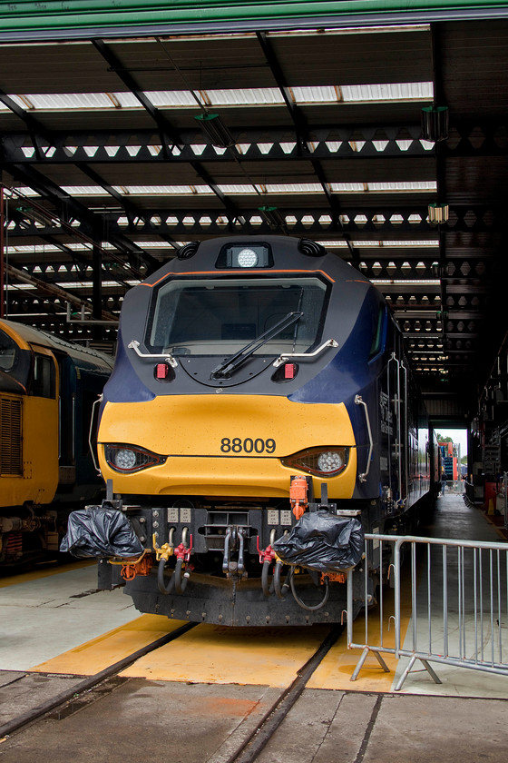 88009, on-display, DRS Kingmoor 
 88009 'Diana' is seen just inside DRS' depot at their Kingmoor facility near Carlisle. This was one of the last of the ten of these electro-diesels that was introduced in 2016. So far, they have proved to be reliable and very useful mixed-traffic locomotives that have largely superseded the veteran class 37s one of which can be seen in the background. 
 Keywords: 88009 on-display DRS Kingmoor