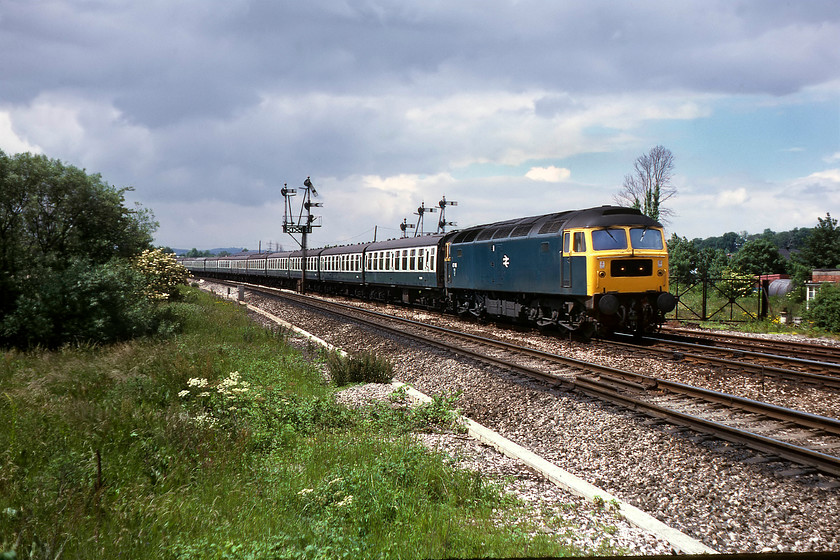 47148, 09.32 Penzance-Wolverhampton (1M39), Silk Mill crossing 
 47148 passes Silk Mill leading the 09.32 Penzance to Wolverhampton 1M39 summer Saturday service. This 47 was a West Country-based member of the class from the early 1970s until transferring to Tinsley in 1987 to then be promptly withdrawn and cut up two years later. This view is all but impossible now due to the huge bridge constructed to take traffic away from the Silk Mill level crossing. It passes just about over where I am standing to take this photograph. 
 Keywords: 47148 09.32 Penzance-Wolverhampton 1M39 Silk Mill crossing