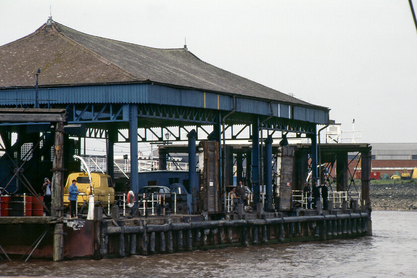 Hull Corporation Pier from MV Farringford 
 The final approach to Hull Corporation Pier reveals a more substantial structure than New Holland Pier on the southern side of the Humber. A number of interesting things are waiting to greet MV Farringford as it approaches. The British Rail Commer PB flatbed van already has its tailgate lowered ready to collect items from the ferry. There is a group of crew members at the far end of the pier waiting to pick up the ropes thrown to them and secure Farringford to the pier head. Also, notice the man and women standing near the Commer van, the man is holding what appears some sort of cine or possibly a video camera and is filming MV Farringford as it approaches. I can't help but wonder if this historic piece of film still exists in some collection somewhere? 
 Keywords: Hull Corporation Pier from MV Farringford Sealink