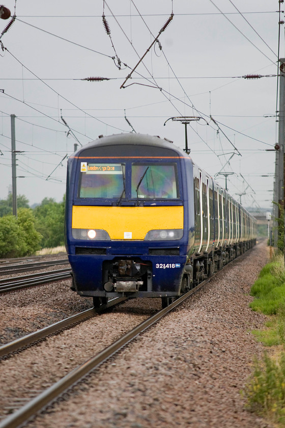 321418, GN 07.32 Peterborough-London King`s Cross (1Y05), Holme Green crossing TL192426 
 Having just left Biggleswade station some two miles away in the distance, 321418 and another Great Northern unit is gathering speed past Holme Green forming the 07.32 Peterborough to King's Cross service. Despite the seemingly exposed position to take this photograph I was standing behind a gate at a farm track crossing point. 
 Keywords: 321418 07.32 Peterborough-London King`s Cross 1Y05 Holme Green crossing TL192426 Great Northern