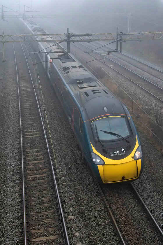 390136, VT 12.16 Manchester Piccadilly-London Euston (1A25, 6E), Victoria bridge 
 The 12.16 1A25 Manchester to London Euston Pendolino service emerges from the fog at Victoria bridge just south of Roade in Northamptonshire. The train is being worked by 390136 that will arrive in the capital in about thirty-five minutes' time. 
 Keywords: 390136 12.16 Manchester Piccadilly-London Euston 1A25 Victoria bridge Avanti West Coast