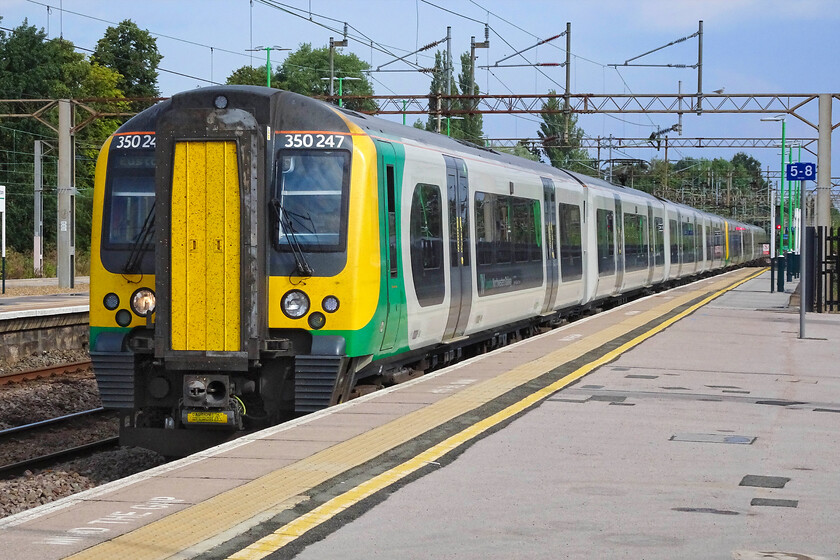 350247, LN 08.36 Birmingham New Street-London Euston (1Y24, 2L), Northampton station 
 Our train south from Northampton to London arrives at the station. We travelled aboard 350247 working the 08.36 Birmingham New Street to Euston 1Y24 service. Thankfully, the air conditioning in our chosen carriage appeared to be working well on what was a very hot day; this is not always the case on these rather tired units. However, I suspect that nothing will be spent on the 350/2 subset as soon they will be going off lease as the Class 730/2s enter service. 
 Keywords: 350247 08.36 Birmingham New Street-London Euston 1Y24 Northampton station London Northwestern desiro