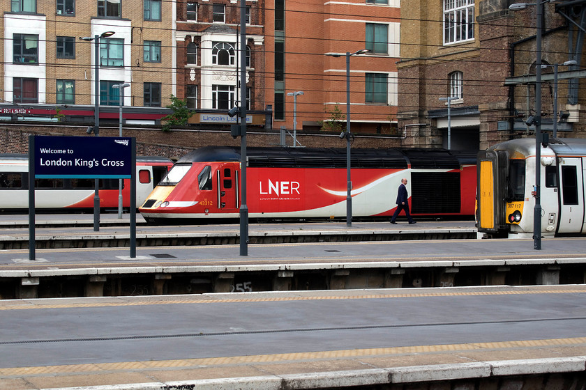 43312, GR 17.00 London King`s Cross-Edinburgh (1S26, 10L) & 387117, GN 16.36 London King`s Cross-Peterborough (1P46, RT), London King`s Cross station 
 There is no doubting where this photograph is taken! A set of Mk. IV stock lead by a Class 91 will work a northbound express in platform zero. HST power car 43312 is leading the 17.00 to Edinburgh whilst just putting in an appearance to the right, 387117 will soon depart with the 1P46 16.36 to Peterborough. 
 Keywords: 43312 17.00 London King`s Cross-Edinburgh 1S26 387117 16.36 London King`s Cross-Peterborough 1P46 London King`s Cross station