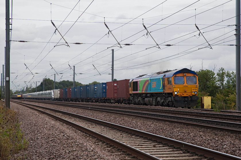 66720 & 700128, 03.14 Dollands Moor-Hornsey EMUD (Via Peterborough) (6X71) & 82225, GR 08.45 Leeds-London Kings Cross (1A18, 1E), Offord DArcy TL213655 
 66720 with its unique livery passes a foot crossing over the ECML just south of Offord DArcy towing brand new 700128 on a gauging run. The working is the out and back 03.14 Dollands Moor to Hornsey EMUD via Peterborough. The train is about to be overtaken by 82225 leading the 08.45 Leeds to King's Cross. 
 Keywords: 66720 700128, 03.14 Dollands Moor-Hornsey EMUD 6X71 82225 1A18 Offord DArcy TL213655