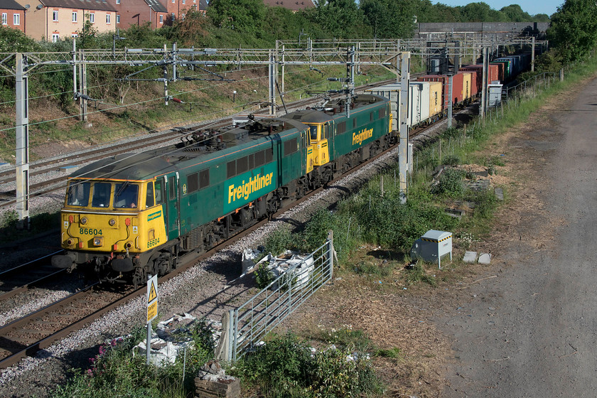 86604 & 86639, 21.25 Coatbridge-Felixstowe North (4L89, 1L), site of Roade station 
 86604 works with 86639 at Roade leading the 21.25 Coatbridge to Felixstowe Freightliner. These locomotives were under a fair bit of power as they passed me making a heck of a racket and going well hauling the very long and well-loaded 4L89. This photograph illustrates the mess and general detritus left by the various trackside contractors as they go about their business. This does nothing for the appearance of the railways and also acts as an attraction for thieves and vandals. 
 Keywords: 86604 86639, 21.25 Coatbridge-Felixstowe North 4L89 site of Roade station Freightliner AL6