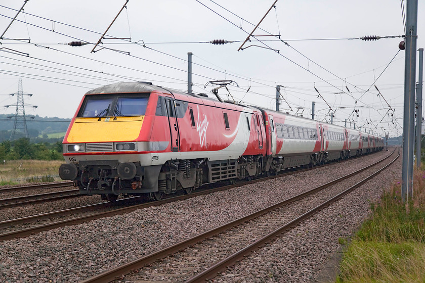 91106, GR 10.35 London Kings Cross-Leeds (1D10 RT), Sandy TL176510 
 The sight and the sound (yes, the sound of an electric can be impressive!) of a class 91 at full chat on the mainline is impressive. Here, 91106 leads the 10.35 King's Cross to Leeds past New Zealand bridge north of Sandy. 
 Keywords: 91106 1D10 Sandy TL176510