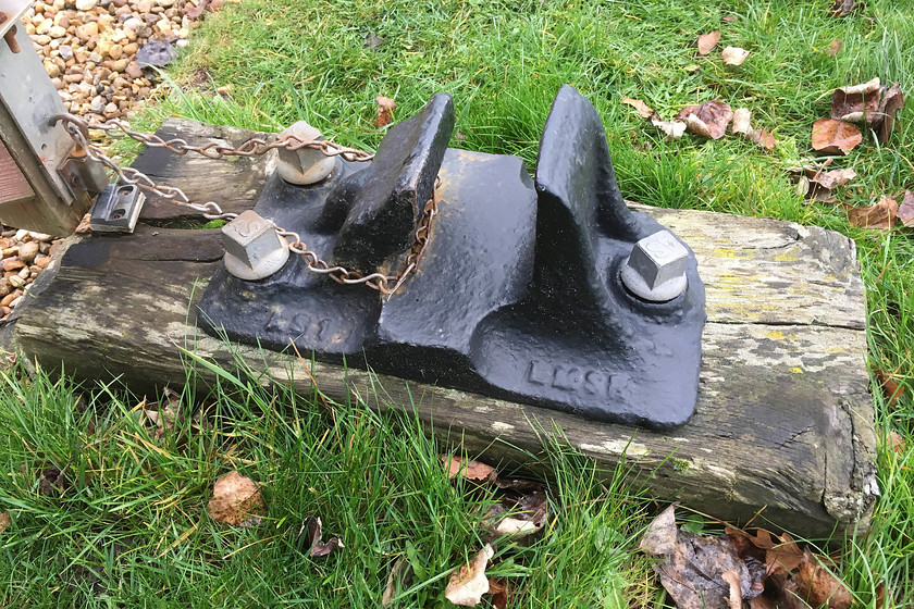 Former SM & J track chair 
 Holding my gate open is a section of sleeper to which I have attached a track chair. The chair was recovered from the small stream at the end of the field in front of my house. It was laying at the point where the SM & J railway passed the field on its route between Ravenstone Woods and Tocester at Roade being casually discarded when the wrecking gangs ripped the infrastructure out in the 1960s.