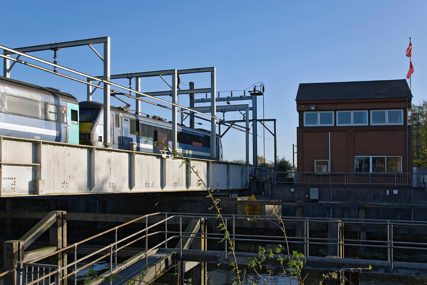 90007, LE 15.00 Norwich-London Liverpool Street (1P47), Trowse swing bridge 
 90007 'Sir John Betjeman' leads the 15.00 Norwich to Liverpool Street Greater Anglia train across the Trowse swing bridge. This interesting structure was opened in 1987 replacing an earlier swing bridge that could not be updated to accommodate the electrification of the GEML. 
 Keywords: 90007 15.00 Norwich-London Liverpool Street 1P47 Trowse swing bridge Greater Anglia 'Sir John Betjeman'