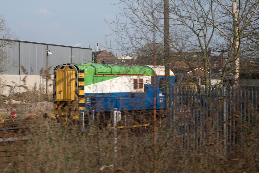 08649, stabled, Electro-Motive, Longport 
 What links 08649 and our new car? Read on........!

08649 dates from March 1959 being based at various depots including Bristol's Bath Road where I saw it many times as a young spotter in the 1970s. It then became one of Wolverton Works' resident shunters involved in the tripping of the Royal Train amongst other things and being named 'Bradwell'. After being sidelined due to crankshaft failure it was removed to a facility at nearby Silverstone where it was completely stripped; a process that took some considerable effort by all accounts. It was then rebuilt with a new six-point eight-litre John Deere diesel engine and a large battery pack from a Tesla matched to a couple of electric motors derived from the same. In this form, the shunter became a testbed for subsequent hybrid conversions with others now in operation at various locations around the country. The locomotive is seen as we pass its present operational base at Electro-Motive's Longport depot which also contains a number of poor-looking Class 56s and 47s one of which can be seen in the background. 
 Keywords: 08649 Electro-Motive Longport