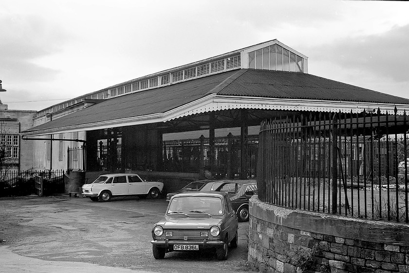 Rear of down side, Bath Spa station 
 In interesting view of the eastern end of Bath Spa station showing the former good loading bay and, what I believe to be, the retaining wall of the old turntable to the extreme right; confirmation anybody? Some interesting period cars in the rather empty station car park, the bronze 1973 registered Simca 1100 had another three years on the road. There is also a Landcrab, a Mk. III Cortina and a Saab 99 in the scene. 
 Keywords: Bath Spa station