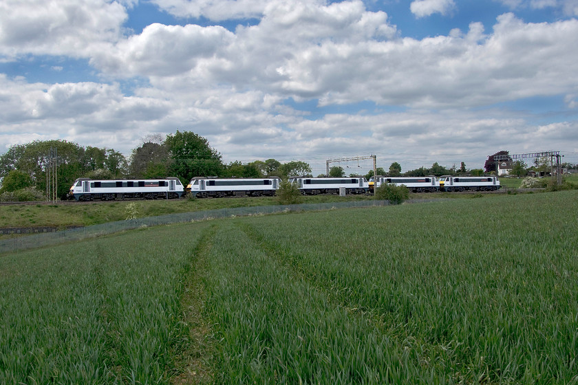 90015, 90004, 90013, 90009 & 90012, 08.42 Norwich Crown Point-Crewe Basford Hall (0Z25, 14L), between Roade & Ashton 
 Five more former Greater Anglia Class 90s head north to their new home at Freightliner's Crewe Basford Hall headquarters. Passing fields between Roade and Ashton the quintuple is led by 90015 'Colchester Castle', with 90004 'City of Chelmsford', 90013, 90009 and 90012 'Royal Anglian Regiment' tucked in behind. Ironic that these locomotives started their working lives on these lines in the late 1980s only to move away and now return again but to become lowly freight locomotives rather than hauling front line passenger trains. 
 Keywords: 90015 90004 90013 90009 90012 08.42 Norwich Crown Point-Crewe Basford Hall 0Z25 14L between Roade & Ashton Colchester Castle City of Chelmsford Royal Anglian Regiment GA Greater Anglia Freightliner