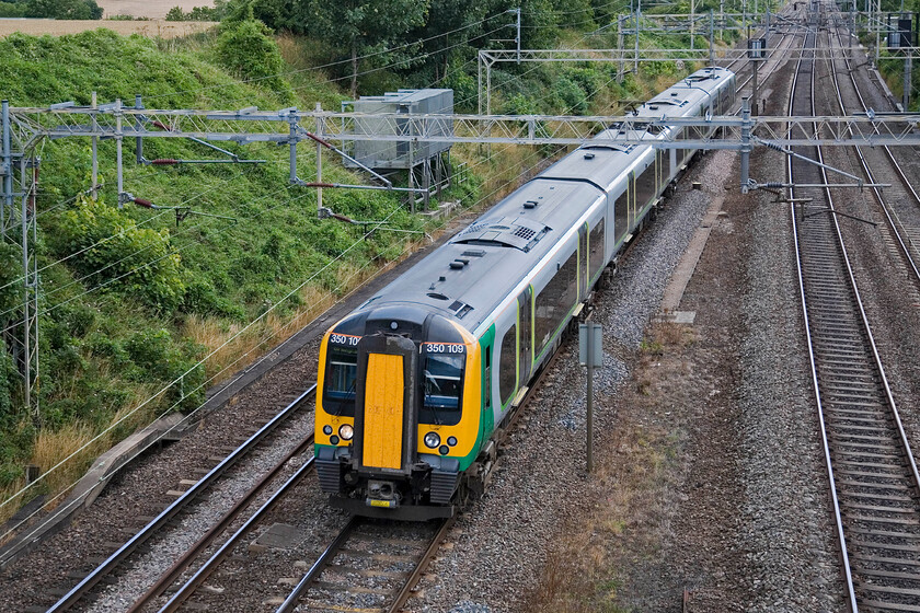 350109, LM 12.34 London Euston-Birmingham New Street, Victoria bridge 
 Another example of a London Midland service that is probably rather overcrowded. London Midland's decision to make most of its off-peak services between London and Northampton single-set four-car trains has drawn much criticism. They need to listen to customers and user groups and review this decision for the new timetable in December. 350109 works the 12.34 Euston to Birmingham service just south of Roade. 
 Keywords: 350109 12.34 London Euston-Birmingham New Street Victoria bridge London Midland Desiro