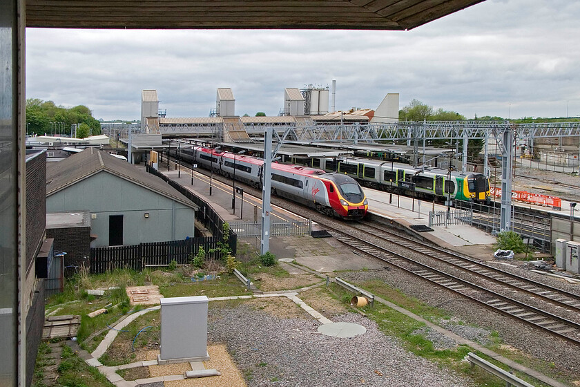 Class 390, VT 11.15 Manchester Piccadilly-London Euston & 350235, LM 12.47 Milton Keynes Central-London Euston, Bletchley station from Bletchley PSB 
 Taken from the front window of the closed Bletchley power box reveals the commanding view of the WCML and the station. As an unidentified Class 390 Pendolino passes southwards working the 11.15 Manchester to Euston service 350235 pauses working the 12.47 Milton Keynes to Euston all stations service. 
 Keywords: Class 390 11.15 Manchester Piccadilly-London Euston 350235 12.47 Milton Keynes Central-London Euston Bletchley station from Bletchley PSB Virgin Pendolino London Midland Desiro