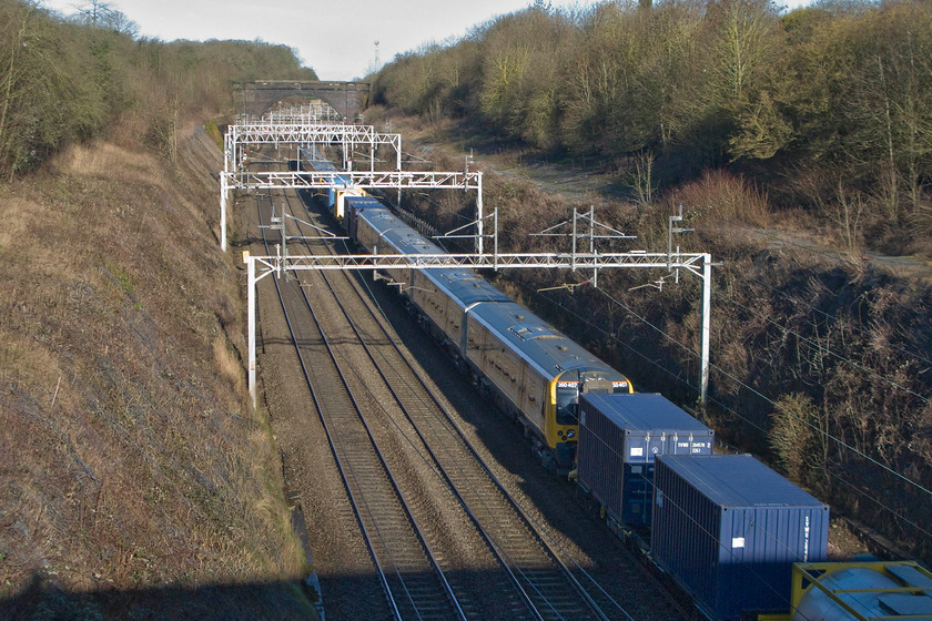 350407, 04.20 Dollands Moor-Trafford Park new stock move (6X50), Hyde Road bridge 
 Brand new 350407 is seen sandwiched in between a number of barrier vehicles being towed through Roade by 92044 'Couperin' out of sight on the front. The Desiro is heading for Manchester as the 6X50 from Dollands Moor for work with TransPennine Express on their Anglo Scottish route from the North West to Glasgow and Edinburgh. 350407 is one of ten Siemens Desiros that have been ordered by TPE some of which are already in service. They are slightly different to the other subsets of the same class as they have been modified for one hundred and ten miles per hour operation and have an interior very similar to TPE's existing fleet of Class 185s. 
 Keywords: 92044 350406 350407 04.20 Dollands Moor-Trafford Park new stock move 6X50 Hyde Road bridge TransPennine Express Desiro Couperin