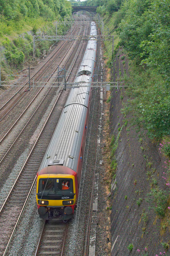 325014, 16.21 Willesden PRDC-Sheildmuir (1S96, 2E), Roade cutting 
 The 1S96 'down mail' is timetabled on the fast line that is always a bit risky at this time of day (around 17.00 at Roade). Nine times out of ten it runs fast from Hanslope to Hillmorton Junctions as it is here passing through Roade cutting. 325014 is leading the train with two other units behind it that I was not able to identify. 
 Keywords: 325014 16.21 Willesden PRDC-Sheildmuir 1S96 Roade cutting Royal Mail