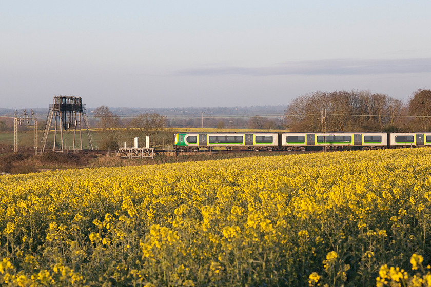 350231, LM 06.14 Northampton Riverside-Milton Keynes Central ECS (5K06), between Roade & Ashton 
 Using the Sigma 80-200 zoom lens to good effect, 350231 is captured passing the oilseed rape fields between Roade and Ashton forming the 06.14 Northampton Riverside to Milton Keynes ECS working. 
 Keywords: 350231 06.14 Northampton Riverside-Milton Keynes Central ECS 5K06 between Roade & Ashton