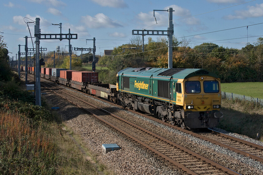 66594, 10.00 Wentloog-London Gateway (4L32, 1L), South Marston SU193869 
 66594 'NYK Spirit of Kyoto' gets up to speed after being checked at Swindon leading the 4L32 10.00 Wentlog to London Gateway Freightliner. It is passing a new footbridge installed at South Marston as part of the GWML electrification that replaced two flat crossings that lay within a few hundred metres of each other. I photographed from both of the foot crossings back in 2014, see..... https://www.ontheupfast.com/p/21936chg/30021196103/x43163-11-55-cardiff-central-london 
 Keywords: 66594 10.00 Wentloog-London Gateway 4L32 South Marston SU193869 Freightliner NYK Spirit of Kyoto