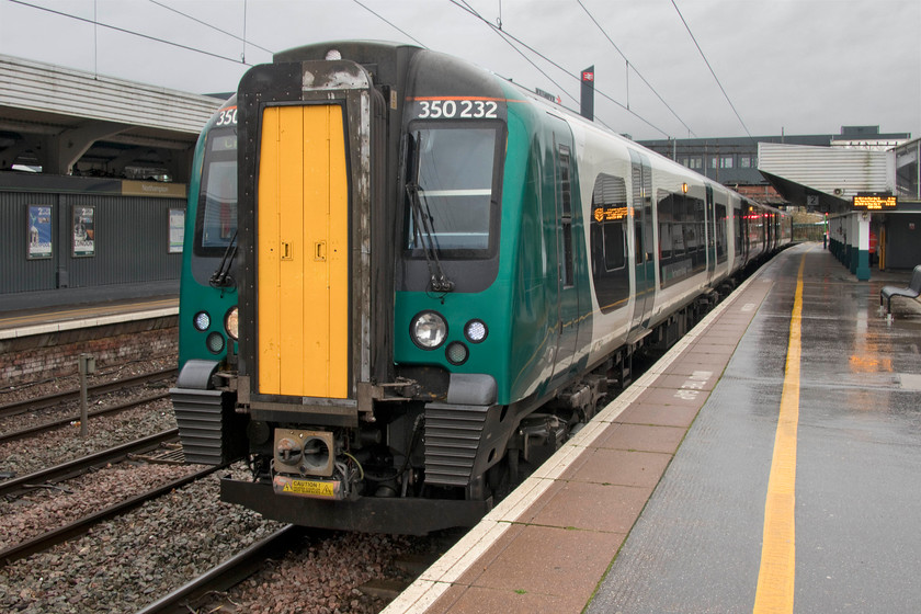 350232, LN 07.13 London Euston-Crewe (9K14, 6L), Northampton station 
 It is the first week of November but the morning is more like mid-January with it being cold, cloudy and raining! Just before departure from Northampton, 350232 stands at platform two with the 07.13 Euston to Crewe. We took this train as the first leg of our journey to Swansea to Birmingham New Street. In a querk of the split ticketing process, the cheapest way to make this journey was first class! 
 Keywords: 350232 07.13 London Euston-Crewe 9K14 Northampton station