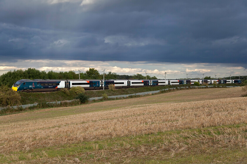 390151 VT, 17.51 London Euston-Liverpool Lime Street (1F18, 5L), Blisworth 
 390151 'Unknown Soldier' passes under some threatening and dramatic-looking clouds as it passes Blisworth in Northamptonshire working Avanti's 17.51 Euston to Liverpool service. I particular;y like the shafts of sunlight finding their way through some gaps in the cloud that contrast strongly with the intense black. 
 Keywords: 390151 17.51 London Euston-Liverpool Lime Street 1F18 Blisworth Unknown Soldier Avanti West Coast Pendolino