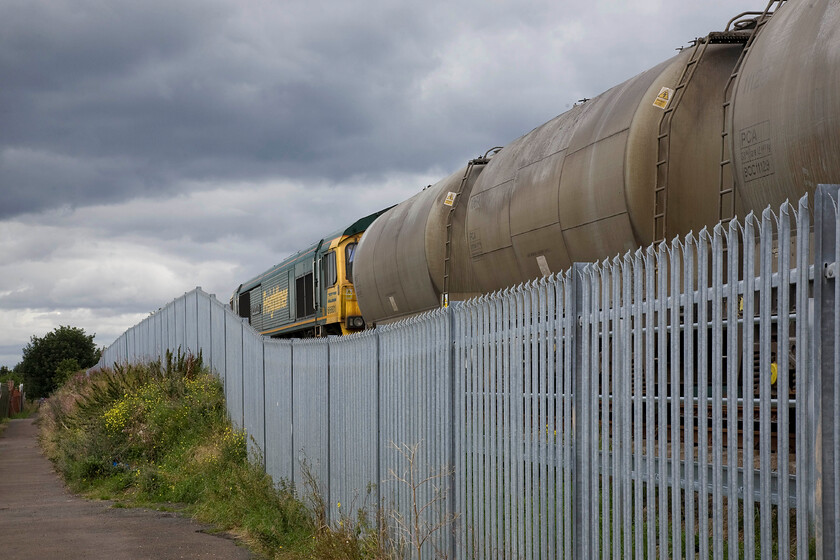 66601, 14.47 Seaham Harbour-Oxwellmains, Seaham Harbour NZ432485 
 Despite being some distance from the harbour itself this location is named as such! 66601 The Hope Valley waits at Tarmacs Seaham Harbour facility to leave with the 14.47 empty cement wagons train to Oxwellmains cement works just south of Dunbar. This photograph is taken from a footpath that runs adjacent to the long siding that diverges from the Durham coast route at Dawdon Junction and is that remains of a number of industrial lines that served the now closed collieries and the coking plant that once were significant employers in the area. Like so much of the traditional industries of this part of the country, nearly all have closed and have been pysically erased from the landscape but their heritage lives on. 
 Keywords: 66601 14.47 Seaham Harbour-Oxwellmains Seaham Harbour NZ432485 The Hope Valley