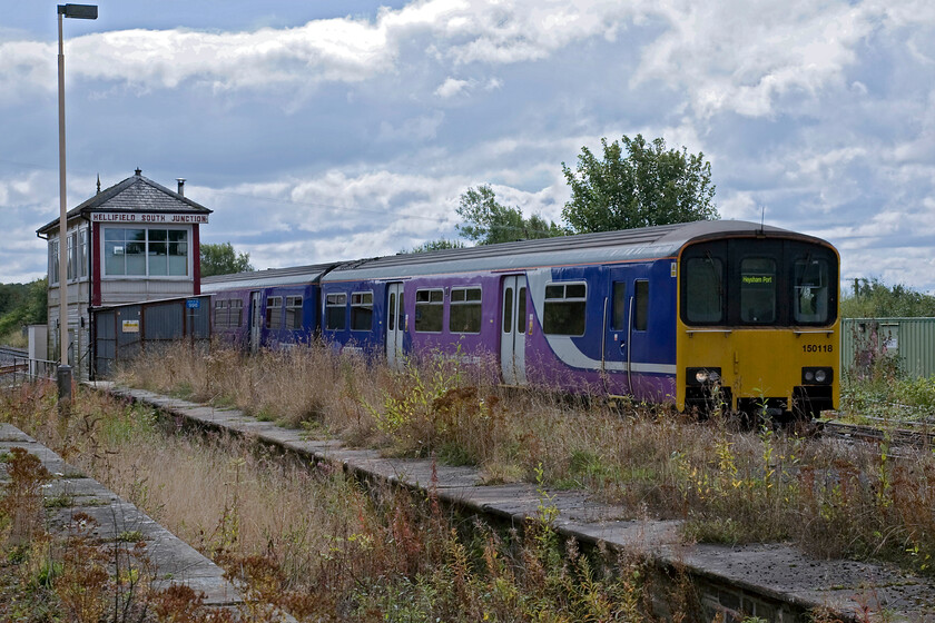 150118, NT 11.14 Leeds-Heysham Harbour (2H84), Hellifield station 
 The 11.14 Leeds to Heysham Harbour Northern service arrives at Hellifield station being worked by 150118. Having passed the 1911 Midland box it is adjacent to the south-facing redundant bay platform. Whilst Hellifield station is a delightful example of a Midland station it is a shadow of its former self and looks very dowdy in places with overgrown platforms and tatty stonework. 
 Keywords: 150118 11.14 Leeds-Heysham Harbour 2H84 Hellifield station