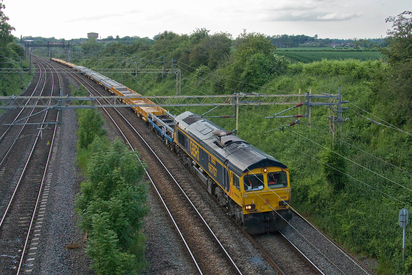 66707, 15.44 Bescot Yard-Wolverton (9G52, 11L), Victoria bridge 
 In preparation for some Bank Holiday weekend engineering works 66707 'Sir Sam Fay' leads the 15.44 Bescot Yard to Wolverton infrastructure working. After a run south to Bletchley the train would then return north to Woverton to be stabled until the work would commence. There a number of new track pannels towards the rear of the train suggesting the nature of the work. 
 Keywords: 66707 15.44 Bescot Yard-Wolverton 9G52 Victoria bridge Sir Sam Fay