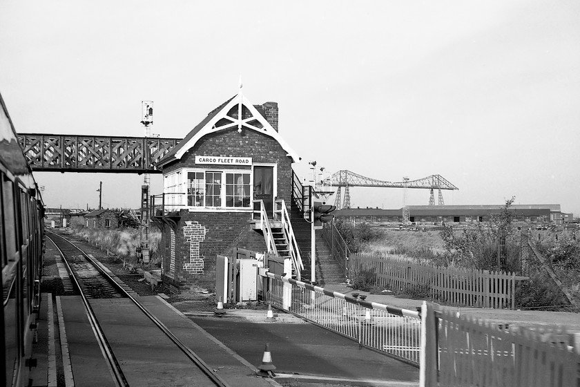 Cargo Fleet Road signal box (NER, 1884) 
 There is no doubting where this photograph is taken! With the Middlesborough transporter bridge dominating the background, Cargo Fleet Road signal box is seen at the level crossing with the road of the same name passing from left to right. The box is an earlier NER example with some more ornate features particularly noticeable is the rather elegant timber work on the gable end. Whilst the box was demolished in 1990 there is still a level crossing at this location but it is for pedestrians and cyclists permitting access to Middlesborough town centre. The view of the transporter bridge is now blocked from this angle by a large building occupied by a building company. 
 Keywords: Cargo Fleet Road signal box North Eastern Railway NER