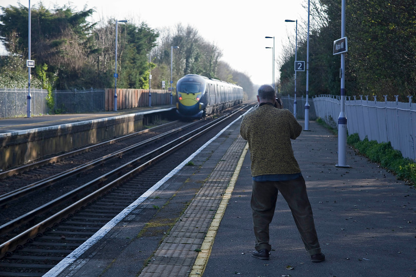 Andy photgraphing 395028, SE, 15.25 London St. Pancras-London St. Pancras (1C42, RT), Martin Mill station 
 The final picture of the day sees Andy getting a 'going away' shot of 365028 working the 15.25 St. Pancras to St. Pancras out and back working at Martin Mill station. Behind the trees to the left there once existed a long single branch line, the route of which can still be made out in places, that led down to Dover harbour. It was constructed in order to facilitate the construction of the harbour in the 1890s. During both world wars, it was used again to serve the many gun emplacements along the cliffs nearby. Also, it carried two 14 inch track mounted cannons nicknamed Winnie and Pooh. After we took these final pictures, we had a quick brew in the station car park and headed for home after a very successful day for both us. I coped some boxes and Andy a number of stations that he could mark off in his book! 
 Keywords: Andy photgraphing 395028 1C42 Martin Mill station