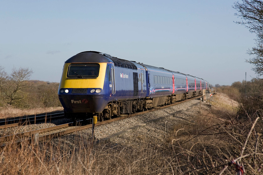 43149, GW 10.00 London Paddington-Paignton (1C09), Knighton crossing SU276890 
 The winter sun has not quite come round enough on this lovely winter's day so as to illuminate the front end of 43149 'University of Plymouth' but it does help create quite a striking image. The HST is working the 10.00 Paddington to Paignton that is routed via Bristol rather than the expected Berks. and Hants. line. It's sobering to consider that views of the GWML such as this one, at the site of the former Knighton level crossing, will be transformed over the coming two years as the electrification masts and wiring arrive. 
 Keywords: 43149 10.00 London Paddington-Paignton 1C09 Knighton crossing SU276890