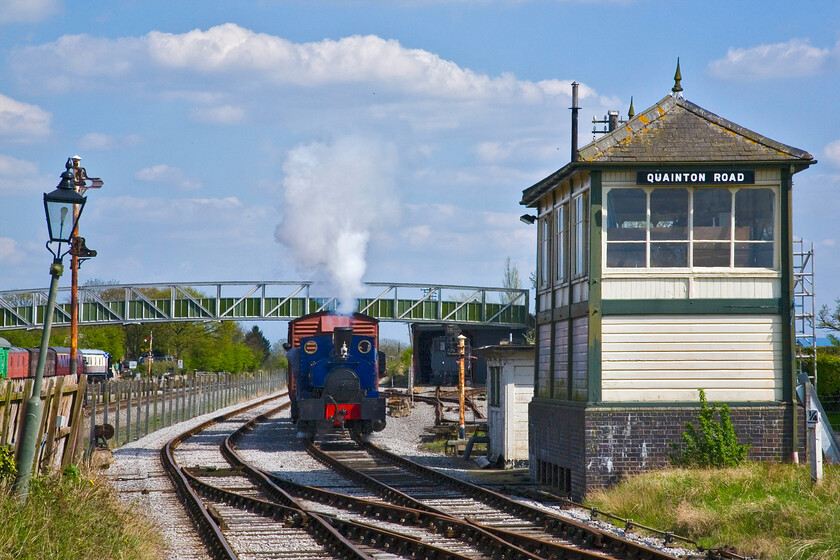 699, demonstration freight, passing Quainton Road signal box (ex Harlington, Mid. 1913) 
 As part of their Bank Holiday gala events, the Buckinghamshire Railway Centre at Quainton Road was operating a demonstration freight. Barclay 0-4-0ST 699 'Swanscombe' is seen hauling the freight wagons past the signal box with a selection of visitors observing from the platform where I am standing. Notice the jaunty angle of the lamp (and the fence for that matter) to the extreme left of the image, this has nothing to do with me tilting the camera or lens distortion! 
 Keywords: 699 demonstration freight Quainton Road signal box Harlington Midland 1913 Buckinghamshire Railway Centre Swanscombe