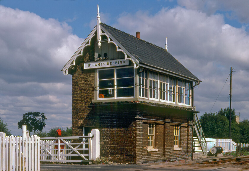 St. James Deeping signal box (GN, 1876) 
 I was so taken with St. James Deeping box back in 19812 that I took another similar photograph from a different angle to the previous one. This 1876 Great Northern box really is a superb and unmolested example of its type that really is set off by the well-painted picket fencing and the mechanical gates. The box survived for a number of years after this image was captured until 2014. However, all is not lost as it is in the process of being completely rebuilt from the ground up at a site very close to its original spot. I have very little information as to how this ambitious plan is progressing; advice, please. 
 Keywords: St. James Deeping signal box