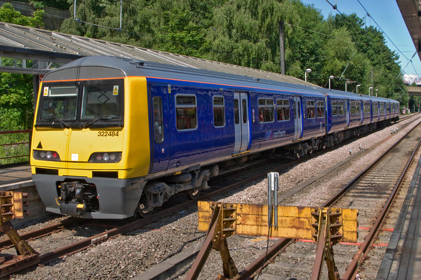 322484, NT 12.11 Bradford Fortser Square-Skipton (2S24), Bradford Forster Square station 
 322484 basks in the summer sunshine at Bradford Forster Square station ready to work the 12.11 to Skipton service. There is some historical disagreement about the name applied to the station with it being referred to variously as Market Street, Exchange as well as Forster Square. The present-day station was opened in 1990 replacing the rather grand old structure located to its immediate right hat is now covered in the inevitable car parking and retailing. The station, along with most of the Wharfedale lines, was to be closed under the Beeching proposals but thanks to the efforts of Bradford Corporation and latterly the West Yorkshire Passenger Transport Executive the lines and station were saved and today flourish with electrification arriving in 1994. 
 Keywords: 322484 12.11 Bradford Fortser Square-Skipton 2S24 Bradford Forster Square station Norther Trains