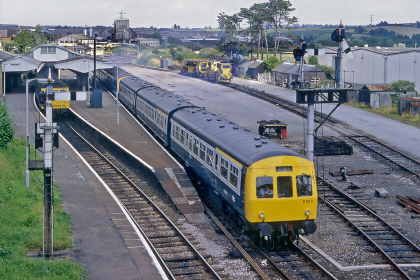 Class 101 DMU, 13.03 Westbury-Weymouth, Yeovil Pen Mill station 
 DMUs cross at Yeovil Pen Mill station. As a Class 102 DMU set B603 (presumably W51522, W59546 and W51450) leaves Pen Mill working the 13.03 Westbury to Weymouth service the 13.00 from Weymouth to Westbury waits to leave. With the line largely singled northwards between Yeovil and Castle Cary and southwards to Dorchester Pen Mill is an important passing place for such services. Notice the route describer on the down starter YPM 60 and 61 signal and the attractive down bracket. 
 Keywords: Class 101 DMU 13.03 Westbury-Weymouth Yeovil Pen Mill station