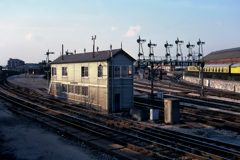 Newton Abbot West signal box (GW, 1927) 
 What a glorious sight to behold! Against a lovely evening springtime sky, the western end of Newton Abbot station is viewed from the junction of Station and Torquay Roads. The view is dominated by the Type 28C West Box which was opened in 1927 and its superb gantry spanning the tracks behind it. Behind the gantry is the purpose-built diesel depot with a couple of Class 50s in view along with the resident Class 08 shunter. To the right are three coaches painted in the publisher David and Charles' corporate colours. The one nearest the camera is a former LNER gangwayed full brake/pigeon van number 70759 that currently resides on the SVR as part of its teak set. I returned a few weeks after this date and took a time exposure standing in what must have been exactly the same position, see.... https://www.ontheupfast.com/p/21936chg/29477848004/x11-newton-abbot-west-signal-box It is a tragedy that this scene today is so different with just three tracks, a much-reduced station and all of the land and trackbeds to the left of the box covered by a car park. Such is progress I suppose! 
 Keywords: Newton Abbot West signal box Great Western Railway