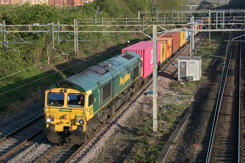 66551, 03.39 Garston-London Gateway (4L52, 72E), site of Roade station 
 Emerging from the shadows of Roade cutting 66551 bursts into the morning sunshine leading the 03.39 Garston to London Gateway Freightliner. As has become common practice, this freight has been routed on the up fast line avoiding the Northampton loop line. This would be unheard of in normal times with a number of early morning up Pendolino workings working from signal to signal. 
 Keywords: 66551 03.39 Garston-London Gateway 4L52 site of Roade station Freightliner