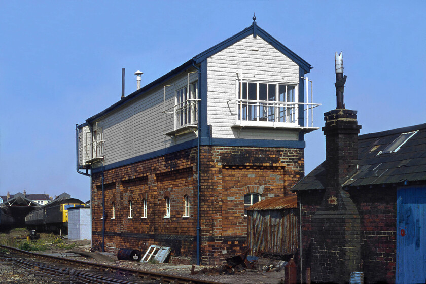 Llandudno signal box (LNW, 1891) 
 Llandudno's signal box (formally named Llandudno Number 2) is seen from the rear probably taken from this angle due to the sun being wrong for a front view. The box was a L&NWR Type 4 opened in 1891 along with Number 1 signal box that was closed when BR rationalised the tracks around the station in 1970. Notice the Class 47 partially obscured behind the box. Close examination of the image reveals a tiny blob of red on its bodyside suggesting that it could well have been 47090 'Vulcan' waiting to return to Essex as seen earlier in the day at Abergele, see... https://www.ontheupfast.com/p/21936chg/30035069772/x47090-shoeburyness-1zxx-abergele 
 Keywords: Llandudno signal box LNW 1891 L&NWR