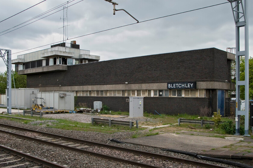 Bletchley PSB (BR, 1965) 
 From the platform end at Bletchley the familiar sight, since 1965 that is, of the BR-built power signal box complete with its large sign. At night the sign is back-lit and shines out brightly announcing to passengers where they are acting as a rather grand running-in sign. With the box now shut (from 31.12.12) it faces an uncertain future and may well go the way of Rugby which has recently been demolished. 
 Keywords: Bletchley PSB BR 1965 London Midland region