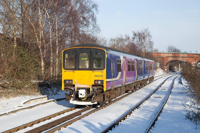 150112, NT 15. 56 Knottingley-Knottingley ECS (5F24), Knottingley station 
 150112 runs out of a very cold Knottingley station having arrived from Leeds. It makes the short journey to Knottingley East Junction where it crosses over and waits before returning again to work its next train back to Leeds. This small movement is the 5F24 15.56 Knottingley to Knottingley ECS. 
 Keywords: 150112, NT (5F24) Knottingley station