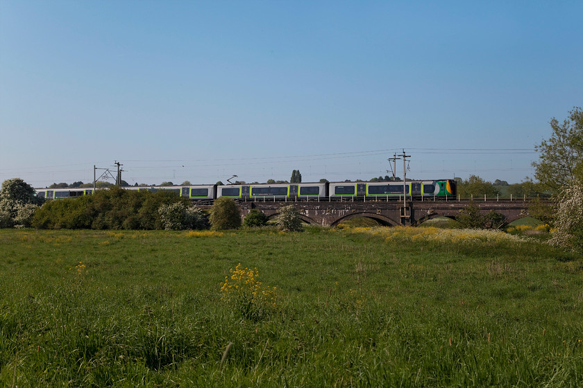 7. 350 114, LN 08.14 Birmingham New Street-London Euston (1Y16, 5L), Kingsthorpe Meadow 
 A train with a lot of green in its livery in a green landscape doesn't work that well, but, at least the sun is on the side! 350114 slows into Northampton working the 08.14 Birmingham New Street to London Euston. The open space in the foreground is an area of meadows enjoyed by the people of Kingsthorpe in Northampton. There have been a number of battles to protect it as various developers have had their sights set on it. 
 Keywords: 350114 1Y16 Kingsthorpe Meadow