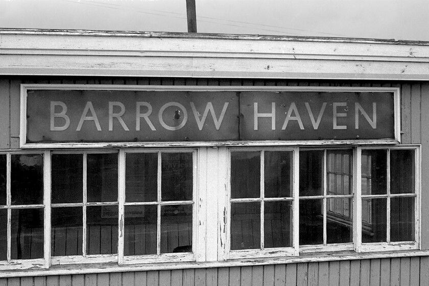 Enamel, Barrow Haven station 
 For such a small station the large enamel sign attached to the front of the waiting room was extraordinarily large! The station was located between New Holland Town and Barton-on-Humber on the branch line spur that led to the North Lincolnshire town. Notice the stove pipe emerging from the roof of the building that was attached to superb pot-bellied stove in the centre of the room. Usage numbers at Barrow Haven have never been particularly high with them dropping to an alarming one hundred and eighty-four during the pandemic hit years of 2020/2021. However, at the time of writing (summer 2022) Network Rail have closed the station for the replacement of the platform so they obviously see a viable future for it. 
 Keywords: Enamel Barrow Haven station