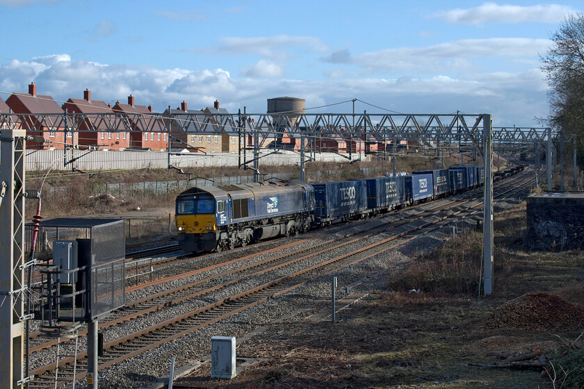 66426, 10.03 Tilbury-DIRFT (4M07, 5E), site of Roade station 
 Yet another ridiculously light loaded Tesco express passes through Roade. With just seven boxes loaded and about the same number of empty flats trailing behind the 4M07 10.03 Tilbury to Daventry is led by 66426 that will have had a very easy time of it. For a number of weeks, the DRS services have all been very lightly loaded with me unable to find out the cause unless anybody can enlighten me. 
 Keywords: 66426 10.03 Tilbury-DIRFT 4M07 site of Roade station Tesco Express DRS Direct Rail Services