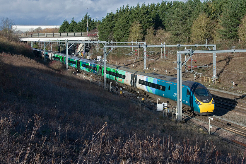 390121, VT 12.13 London Euston-Manchester Piccadilly (1H19, 9L), Loughton Redway bridge, Milton Keynes 
 Catching some extremely welcome winter sunshine as it passes Milton Keynes, 390121 'Opportunity' is seen working the 12.13 Euston to Manchester service. I am standing on one of Milton Keynes' Redway bridges where pedestrians, cyclists and horse riders are kept separated from cars. This bridge is immediately north of Milton Keynes station in the district of Loughton. 
 Keywords: 390121 12.13 London Euston-Manchester Piccadilly 1H19 Loughton Redway bridge, Milton Keynes AWV Avanti West Coast Pendolino Opportunity