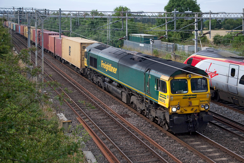 66570, 02.57 Felixstowe North-Ditton (4M45) & 390136, VT 07.23 London Euston-Birmingham New Street (0905, 1L), Hungate End SP784465 
 66570 heads north on the down slow with the 4M45 02.57 Felixstowe North to Ditton Freightliner. It has just been overhauled by 390136 'City of Coventry' working the 07.23 Euston to Birmingham New Street. The trains are seen passing Hungate End just north of Wolverton. 
 Keywords: 66570 02.57 Felixstowe North-Ditton 4M45 390136 0905 Hungate End SP784465