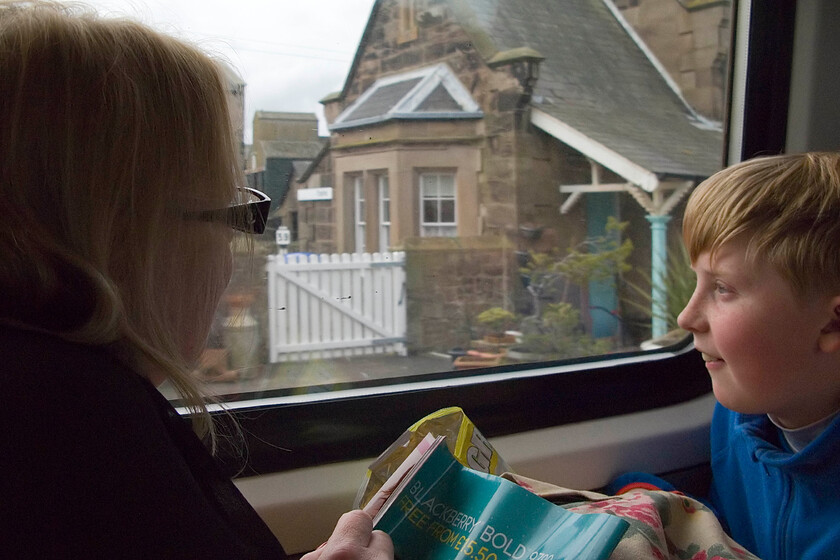 Carol & Chaz on board 09.00 London King's Cross-Edinburgh Waverley, passing Chathill station 
 A photograph that means something to us as a family! My wife and son grab a glance at the remote and lightly used Chathill station close to the Northumbrian coast between Berwick and Newcastle. Two years ago in 2011 we stayed at this station for a week's summer holiday as the top floor is set up as a very nice holiday let. As well as enjoying all the delights of the area we were treated to trains racing past exactly as we are doing here on the 09.00 King's Cross to Edniburgh! 
 Keywords: Carol Chaz on board 09.00 London King's Cross-Edinburgh Waverley Chathill station