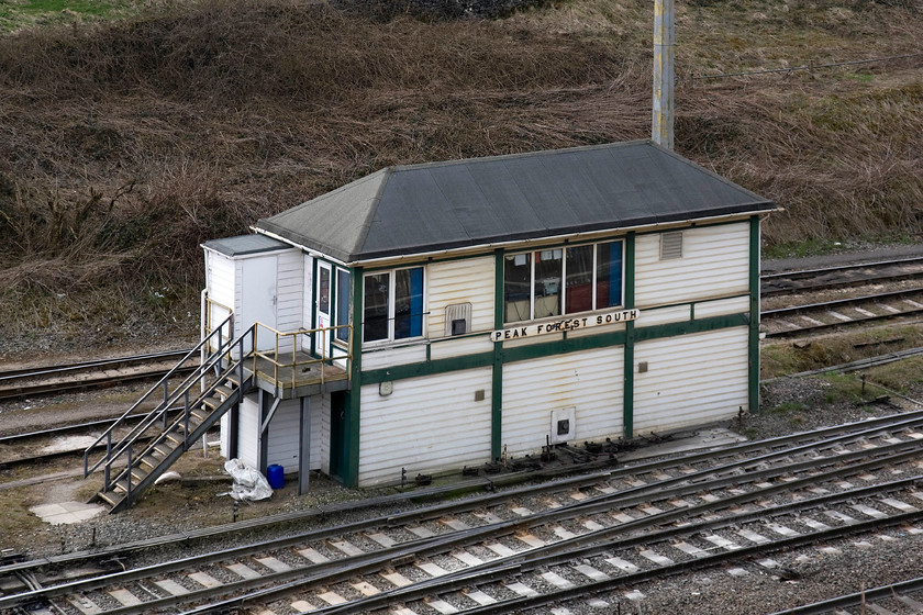 Peak Forest South signal box (Midland, 1925) 
 It is nice to see Peak Forest South signal box is still proudly carrying a genuine-looking LMS nameboard of some kind but I doubt it is an original but I stand to be corrected. Despite the felted roof, the uPVC cladding and windows, the box cannot disguise its Midland origins being of their type 4d design but one that was actually erected by the LMS in 1925. This was a replacement box for an 1891 structure on the opposite of the line. To get this image required a walk down a very steep field that was full of inquisitive sheep and then a trudge back up it to the road whilst Andy patiently waited in the car. 
 Keywords: Peak Forest South signal box